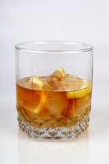 Glass of whiskey with ice and lemon, white background, close-up