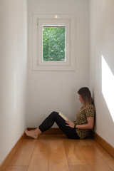 Chica leyendo un libro en casa