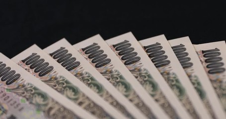 Japanese currency 100,000 yen on the black background panning