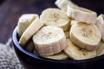 sliced ​​banana in wooden pot, healthy food. Ingredient for vegan bread or homemade cake.