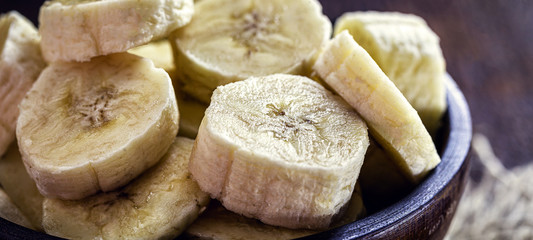 sliced ​​banana in wooden pot, healthy food. Ingredient for vegan bread or homemade cake.