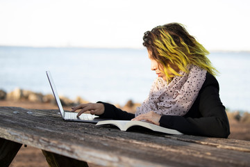 business woman working outdoors with computer on wooden table