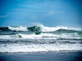Big waves on the north shore of Oahu with aquamarine seas, white foam and blue skies.