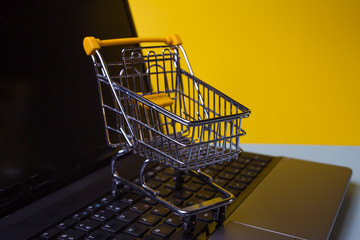 E-Commerce. Online shopping, shopping cart on laptop keyboard.