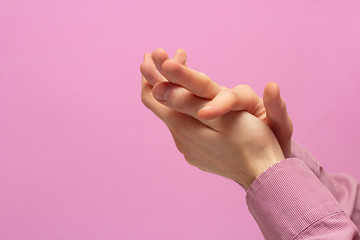 The guy rubs his hands. pink background