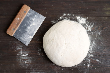 Freshly prepared yeast dough for health homemade bread on a gark brown wooden background.
