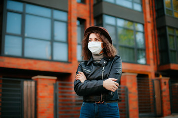 young woman  in the city in mask. coronavirus. covid-19. 