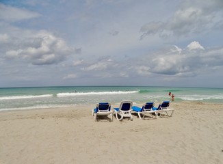 Fototapeta na wymiar Fotografía curiosa de unas hamacas en la orilla de la playa de Varadero, Cuba, en el Mar Caribe, esperando a ser usadas.