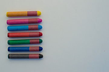 Naklejka premium colored crayons on white background