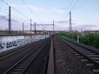 Fototapeta na wymiar czech railway tracks at sunset and in the background is prague architecture in spring 2020
