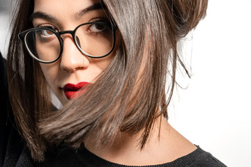 Fototapeta premium Portrait of young woman wearing eyeglasses and posing on camera