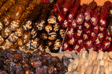 Cevizli sucuk made by dipping a string with walnuts into a grape molasses mixture