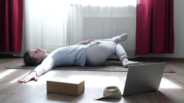 Beautiful woman doing stretching twisitng exercise on the floor