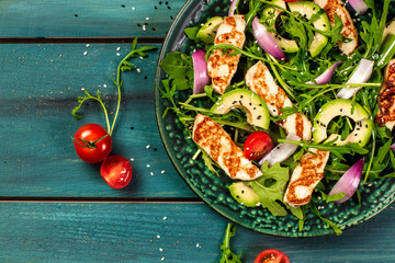 The concept of oriental cuisine. National Cyprus Salad with grilled Halloumi cheese, tomatoes, avocado, arugula. banner menu recipe place for text. Flat lay