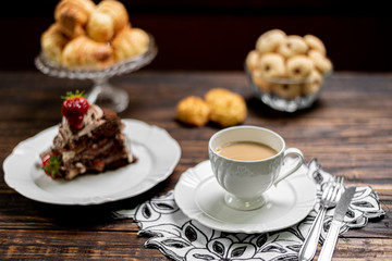 Coffee cup and chocolate cake on wooden table background