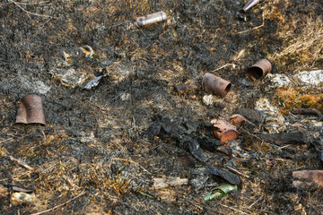 environmental pollution concept. unauthorized dump. burnt grass and landfill in it