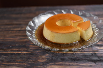 Milk Pudding or Pudim de leite. Brazilian dessert homemade caramel custard pudding. Traditional brazilian flan on wooden background