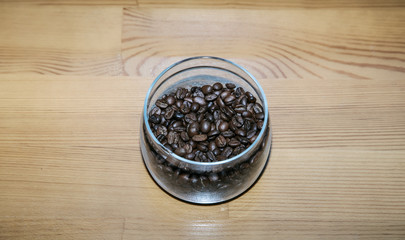 Obraz na płótnie Canvas Coffee beans in a glass jar on a wooden table