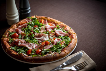 Italian pizza with prosciutto, cherry tomatoes
