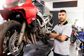 Fototapeta na wymiar Motorbike repairman working in repair shop.
