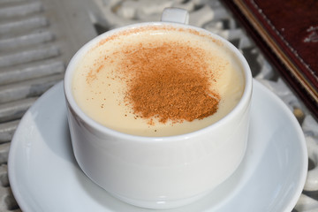 white cup of salep milky hot drink of Turkey with cinnamon powder and sticks healthy spice