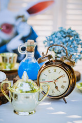 Obraz na płótnie Canvas alarm clock on a table decorated under Alice in Wonderland