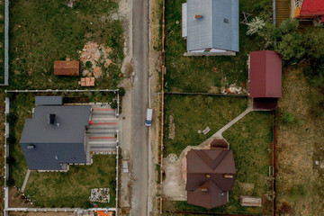 Aerial top view of a house with paved yard with green grass lawn with concrete foundation floor