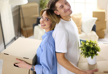 Couple holding boxes for moving the hands and looking inside box