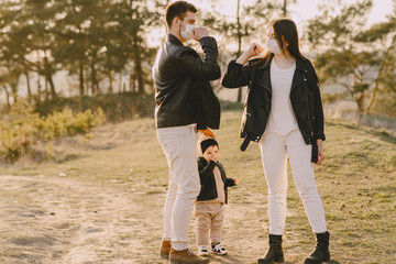 Obraz premium Family with cute little son. People in a summer field. Corona virus theme.