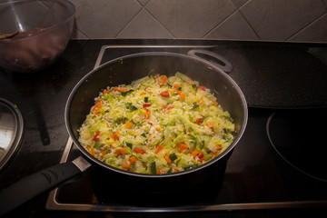 Cooking pan with rice and sautéed vegetables.
