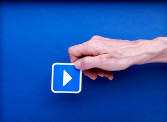 main qui tient une illustration de flèche vers la droite sur fond bleu