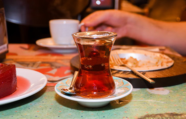 Turkish tea in traditional glass on tray closeup. Black tea specialty served in a restaurant
