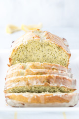A close up front facing view of a lemon poppy seed loaf sliced into and ready for eating.
