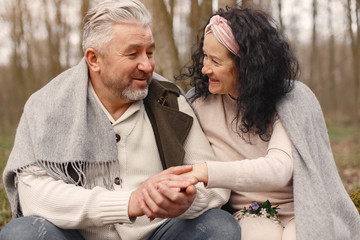 Seniors in a forest. People walks. Family with spring's flowers.