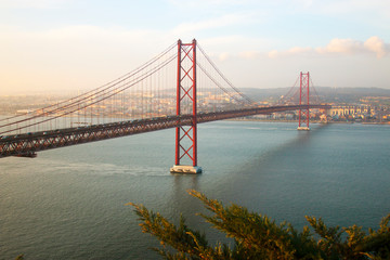 Fototapeta na wymiar View of 25th of April Bridge, a suspension bridge connecting the city of Lisbon, capital of Portugal, to the municipality of Almada on the left (south) bank of the Tagus river. Lisbon, Portugal