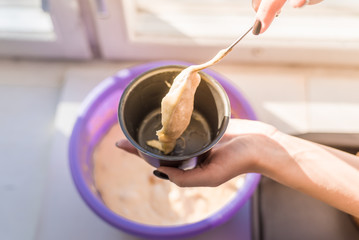 Woman puts dough in a cupcake mold with a spoon