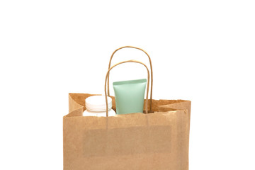 paper bag with cream and cosmetics on white background.