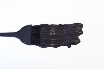 Black hair brush with a trace of black hair dye isolated on white background.