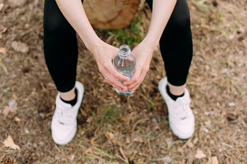 girl sportswear sneakers holds bottle water hands