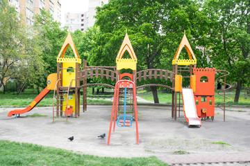 Colorful playground in a square inside a big city. Empty children's playground closed for quarantine days.