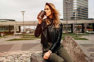 Young woman drinking hot beverage and looking into distance in spring time