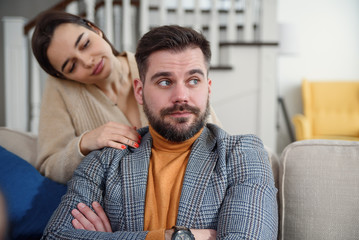 Attractive woman apologizing to frustrated man after quarrel, doubting boyfriend ignore, girlfriend...