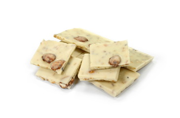 White chocolate pieces with pistachios and almonds isolated on white background.
