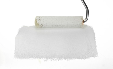 Obraz premium Painting a rough wall with roller. Paint roller leaving stroke of white color over a rustic background. usable for text and messages.