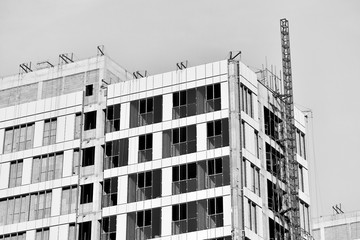 Close-up of steel frame under construction under blue sky background, black and white effect