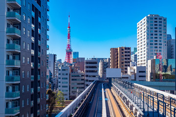 Naklejka premium Japan. A trestle near skyscrapers in Tokyo. Railroad rack with rails in Japan. The railway bridge is located close to the houses. City landscape. Television Tower in Japan. High Speed Train
