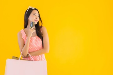 Portrait beautiful young asian woman with colorful shopping bag with smart mobile phone and credit...
