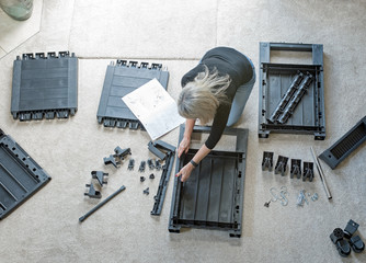 Mature Woman Assembling Outdoor Furniture Parts