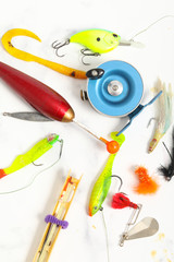 many fishing equipement on white marble background
