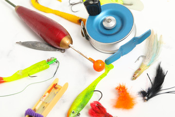 many fishing equipement on white marble background